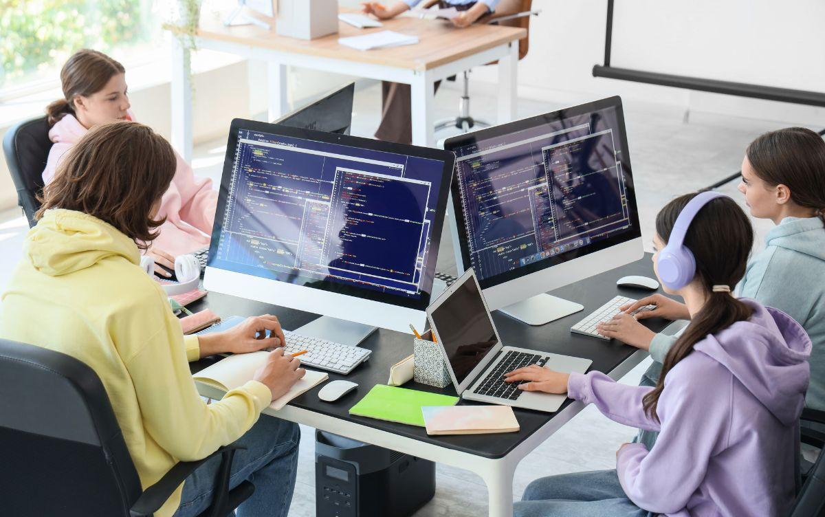 Studenti che lavorano al computer in un laboratorio informatico, sviluppando codice e competenze tecniche tipiche degli ITS (Istituti Tecnologici Superiori)